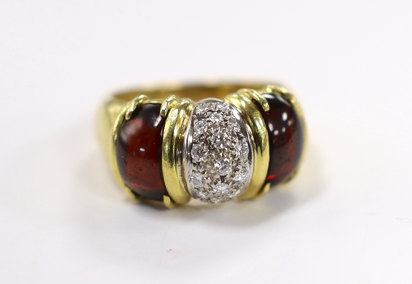 A modern 750 yellow metal and diamond cluster set dress ring, with two stone cabochon garnet set shoulders, size Q, gross weight 9.7 grams.